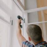 Anonymous man installing window in room