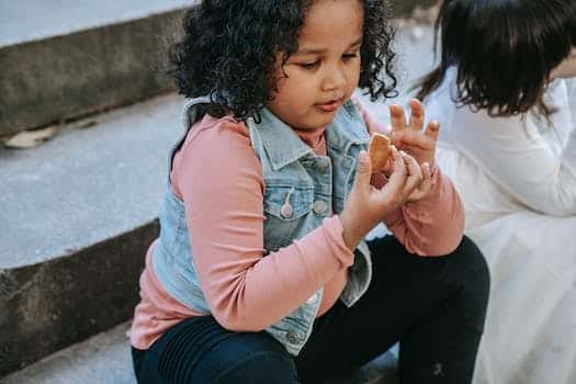 Black girl having gingerbread treat with friend