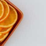 Minimalistic layout of fresh orange slices on ceramic rectangular plate