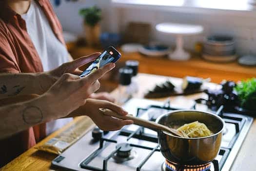 Person Taking a Picture of Cooking Spaghetti