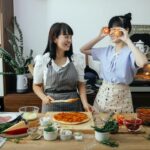 Positive women having fun cooking pizza