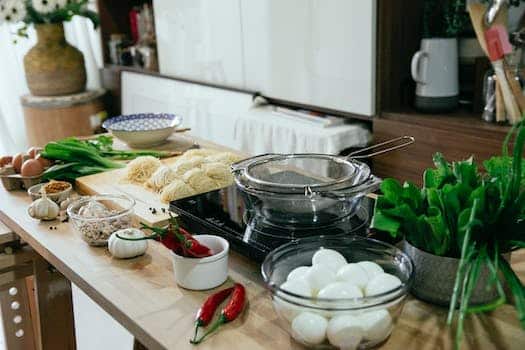 Table with spices chopping board with noodles and bowls in kitchen