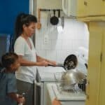 Asian woman and daughter cooking lunch in modern kitchen