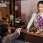 Ethnic mother standing in kitchen near anonymous girl at home