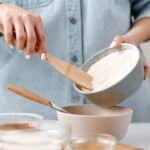 Person Adding Flour into a Bowl