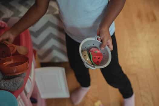 Unrecognizable child playing with fake kitchenware