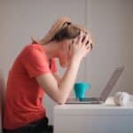 Woman in Red T-shirt Looking at Her Laptop