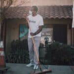 Man Wearing Face Mask Cleaning the Sidewalk