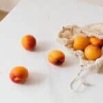 Organic sweet apricots in cotton sack placed on table