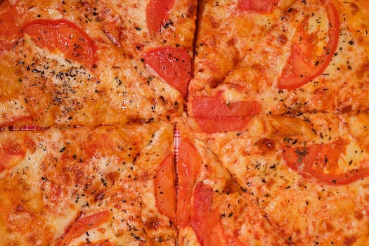 Pizza with tomatoes and cheese on table