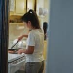 Woman cooking lunch in light kitchen