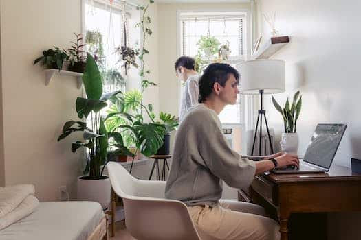 Woman typing on laptop against girlfriend at home