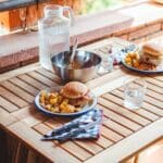 Appetizing burgers and potato wedges on table