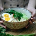 Crop unrecognizable woman touching bowl with traditional ramen soup