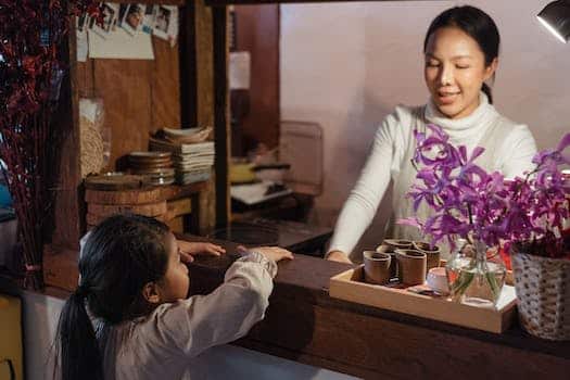 Ethnic mother standing in kitchen near anonymous girl at home