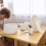 Focused young artist painting ceramic bowl