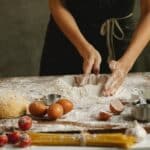 Woman making dough on table