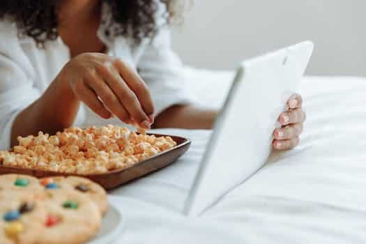 Woman Watching on a Digital Tablet with Snacks