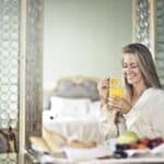 Cheerful woman enjoying breakfast in morning