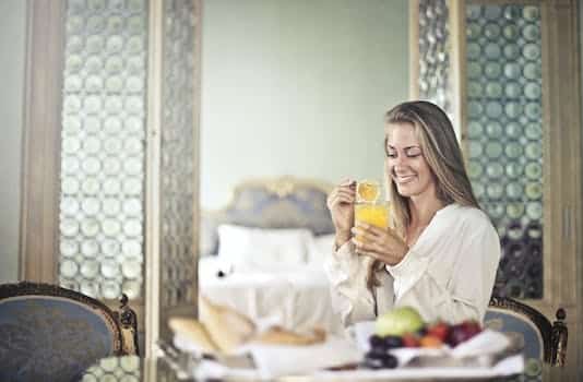 Cheerful woman enjoying breakfast in morning