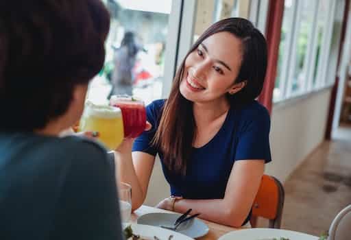 Happy Asian woman with drink in cafe