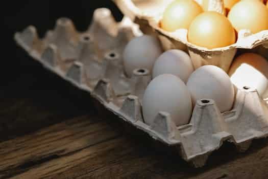 Carton box with fresh eggs placed on wooden surface