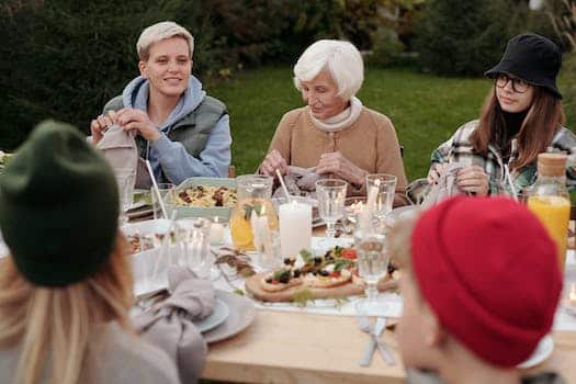 Cheerful family enjoying dinner party together in countryside