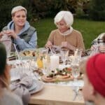 Cheerful family enjoying dinner party together in countryside