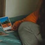 Faceless woman choosing pictures on bed