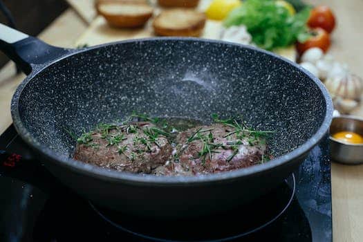 Frying pan with patties in kitchen