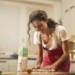 Happy woman with rolling pin cooking at home