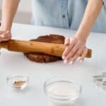 Person Flattening a Chocolate Dough With Rolling Pin