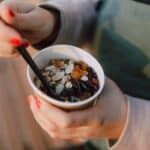 Person holding a Disposable Cup filled with Oatmeal