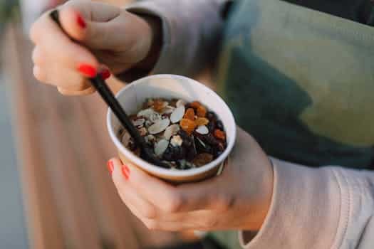 Person holding a Disposable Cup filled with Oatmeal