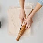 Person Holding Brown Wooden Rolling Pin