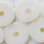 Top view closeup of ripe organic yellow peeled onion cut into rings and placed on white marble tabletop