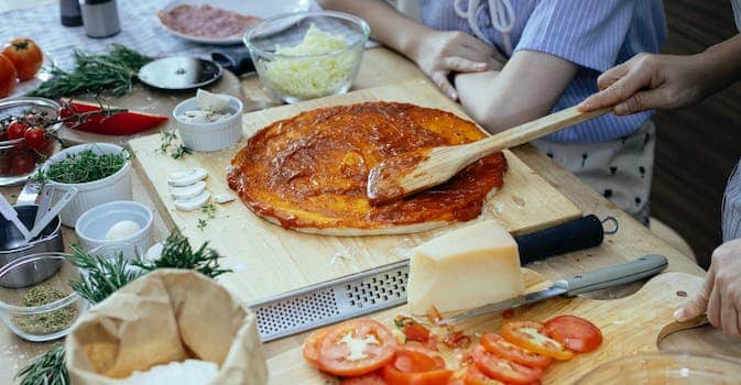 Women in process of preparing homemade pizza