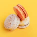 From above of delicious little homemade macaroons placed on bright yellow background of studio