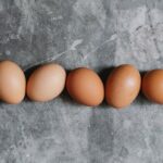 Whole raw brown eggs arranged on table in kitchen