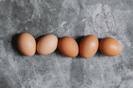 Whole raw brown eggs arranged on table in kitchen